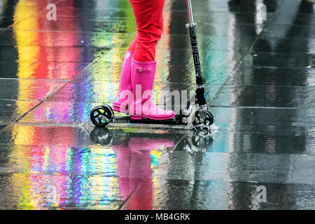 Mehrfarbige Reflexionen von Frau Reiten Roller in Merseyside, Großbritannien. April 2018. Southport, Merseyside. April 2018. Wetter in Großbritannien. Die Pendler, die nach dem langen Feiertagswochenende in Southport in Merseyside wieder zur Arbeit kommen, werden im April von Regenschauern heimgekehrt. Prognostiker prognostizieren einen ziemlich bewölkten und duschigen Nachmittag, einige der Schauern sind stark mit dem Risiko von Hagel und Donner. Quelle: Cernan Elias/Alamy Live News Stockfoto