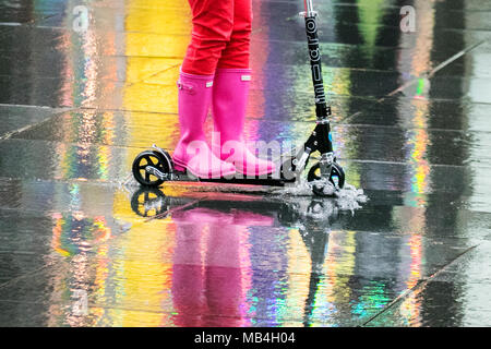 Mehrfarbige Reflexionen von Frau Reiten Roller in Merseyside, Großbritannien. April 2018. Southport, Merseyside. April 2018. Wetter in Großbritannien. Die Pendler, die nach dem langen Feiertagswochenende in Southport in Merseyside wieder zur Arbeit kommen, werden im April von Regenschauern heimgekehrt. Prognostiker prognostizieren einen ziemlich bewölkten und duschigen Nachmittag, einige der Schauern sind stark mit dem Risiko von Hagel und Donner. Quelle: Cernan Elias/Alamy Live News Stockfoto