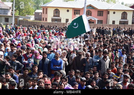 Pulwama, Jammu und Kaschmir, Indien. 7. April 2018. - Teilnehmer winken ein pakistanischer Flagge während der Beerdigung. Tausende Menschen nahmen an der Beerdigung Prozession der Getöteten militanten Mussavir Wani, der am Freitag, 06. April 2018 wurde in einem kurzen Shootout im Bereich der Kangan Pulwama Bezirk getötet, an Delipora Dorf Pulwama Bezirk hielt einige 30 km von Srinagar Sommer Hauptstadt des indischen Teil Kaschmirs. Credit: ZUMA Press, Inc./Alamy leben Nachrichten Stockfoto