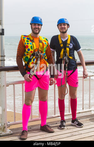 Bournemouth, Dorset, Großbritannien. 7. April 2018. UK Wetter: Nach einem feuchten Start in den Tag die Sonne versucht, heraus zu kommen, obwohl es auf der kühlen Seite Besucher gehen nach Bournemouth Strand am Meer während der Osterferien zu genießen. Die hellen und farbenfrohen ein paar Jungs auf einem Junggesellenabschied für eine Fahrt auf dem Drahtseil Credit gekleidet: Carolyn Jenkins/Alamy leben Nachrichten Stockfoto