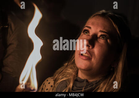 Jerusalem. 7. April 2018. Ein christlich-orthodoxen Frau hält eine Kerze aus einer Flamme, die aus dem Grab geglaubt, die Grabstätte von Jesus Christus zu sein, während der Zeremonie des Heiligen Feuers, an der Kirche des Heiligen Grabes in Jerusalem, 07. April 2018 beleuchtet. Foto: Ilia Yefimovich/dpa Quelle: dpa Picture alliance/Alamy leben Nachrichten Stockfoto