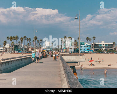 Menschen gehen auf dem Pier und genießen Sie ein Sonnenbad am Strand. Blick vom Venice Beach Pier. Stockfoto