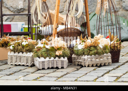 Traditionelle Osterdekorationssymbole aus natürlichen Materialien, Kaninchen, Hühnern, Henne, Strohhalm, Eiern, Ostermarkt. Stockfoto