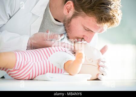 MODEL RELEASED. Doktor, der säugling HLW Training Dummies. Stockfoto