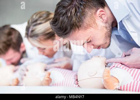 MODEL RELEASED. Doktor, der säugling HLW Training Dummies. Stockfoto