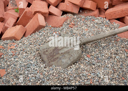 Viele rote Ziegel liegen auf dem Kies Stockfoto