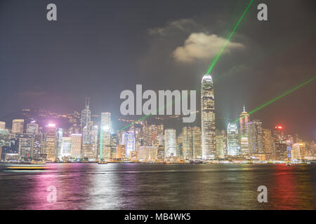 Hongkong - 20. SEPTEMBER 2017; Lichter von Hong Kong kommerzielle Skyline spiegelt sich auf ruhigem Wasser auf den Victoria Harbour und Grünen lazer Lichtstrahlen projiziert Stockfoto