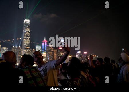 Hongkong - 20. SEPTEMBER 2017; körniges Bild Lichter von Hong Kong defokussierten kommerzielle Skyline bachground zu Gruppe einschließlich selfie unter Mann hält Stockfoto