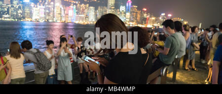 KOWLOON HONG KONG, September 20, 2017; Touristen sammeln entlang laufen od Sterne zu sehen und nehmen selfie Comercial auf Victoria Harbour und die Skyline bei Nacht. Stockfoto