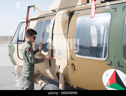 Einen afghanischen Luftwaffe Pilot inspiziert ein AFGHANISCHER UH-60 Februar 18, 2018, in Kandahar Air Wing, Afghanistan. Der Pilot beendet die erste Phase der Ausbildung, Flugzeuge Qualifizierungsmaßnahmen, und ist derzeit in der Mission Qualifizierungsmaßnahmen, wo er über mehr voraus Manöver und wie Truppe und Frachtbetrieb in Kampfsituationen zu Verhalten lernen. Stockfoto