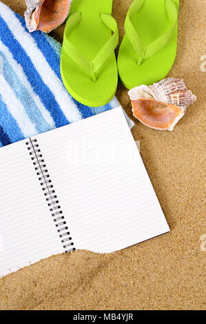 Strand Hintergrund mit Handtuch, Flip Flops und ein leeres Notebook. Stockfoto