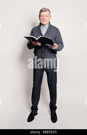 Senior Geschäftsmann mit Jahresbericht in seinen Händen. Volle Portrait von reifer Mann Stockfoto