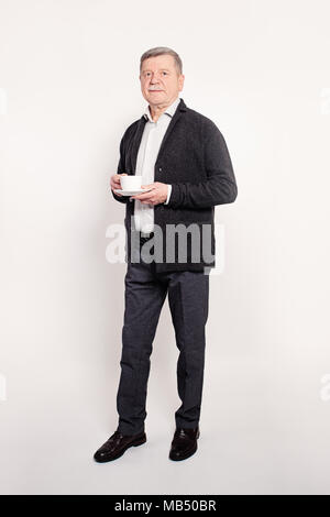 Senior Geschäftsmann mit einer Unterbrechung. Reifer Mann mit einer Tasse Kaffee Stockfoto