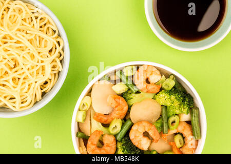 Im chinesischen Stil King Prawn mit Ingwer und Frühlingszwiebeln Brokkoli vor einem grünen Hintergrund Stockfoto