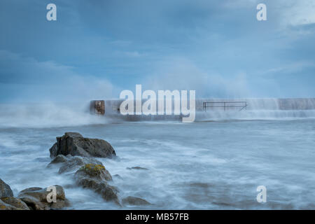 Sturm - Storm Wellen brechen über den Hafen Wand Stockfoto
