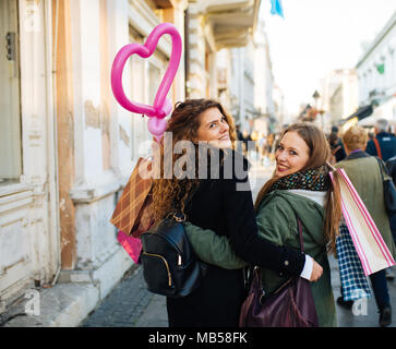 Zwei attraktive junge Frauen ist mit Einkaufsmöglichkeiten zufrieden und auf der Straße Stockfoto