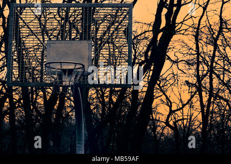 Korb für Basketball auf dem Hintergrund der Sonnenuntergang und Bäume Stockfoto