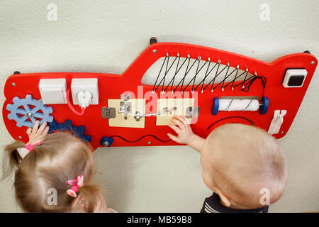 Cute Kleinkinder spielen mit langen Board im Kindergarten. Stockfoto