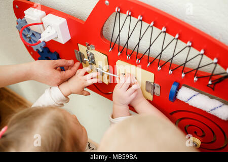 Cute Kleinkinder spielen mit langen Board im Kindergarten. Stockfoto