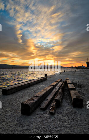 Sonnenuntergang auf Varna Dock mit hölzernen Bahnschwellen im Vordergrund Stockfoto