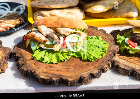 Leckere Burger mit Fleisch, Käse und frischem Gemüse auf Holzbrett. Einfache Idee für Sandwich Stockfoto