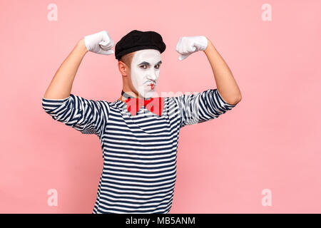 Starke Mann im gestreiften Pullover, weiße Handschuhe Übersicht muscule. Clown, Artist, Mime. Studio shot, rosa Hintergrund Stockfoto