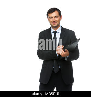 Hübscher junger Geschäftsmann in Business sut, blaues Hemd und Krawatte holding Tablet in Ledertasche. glücklichen Ausdruck. Jemand Gruß. Studio shot iso Stockfoto