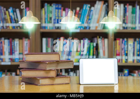 Altes Buch auf dem Schreibtisch in der Bibliothek mit Tablet und Luxus Beleuchtung Dekoration Stockfoto