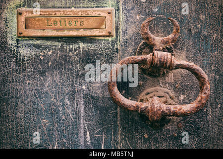Alten rostigen Mail Letter Box und Rusty Dekorative Klopfer auf einem Verwitterten Tür, text Buchstaben Stockfoto