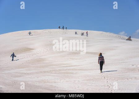 Menschen klettern und Sandboarding auf den Sanddünen von Lancelin in Westaustralien Stockfoto