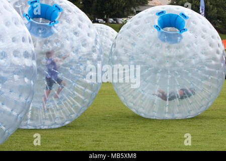 Kinder drängen sich um in großen zorbs auf einer Rasenfläche im Atlanta Eis Festival in der Piedmont Park, am 27. Juli 2013 in Atlanta, GA. Stockfoto