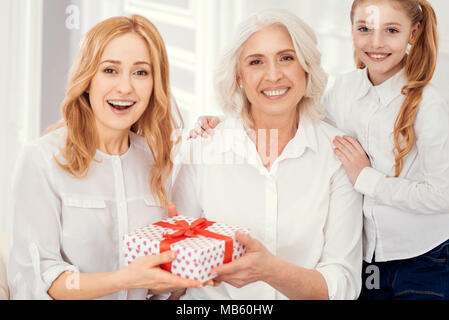 Überrascht, Frau, Geschenk von Ihrer Mutter und Tochter Stockfoto