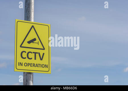 CCTV-Kamera in Betrieb gelbes Warnschild - Watching Over You, Überwachung/Orwellschen/Big Brother/Nachrichtendienste Konzepte. Stockfoto