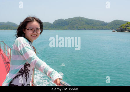 Junges Mädchen tragen Brillen sind Reisen mit dem Schiff die schöne Aussicht auf das Meer zu genießen und die Insel im Sommer im Mu Ko Ang Thong National Pa Stockfoto