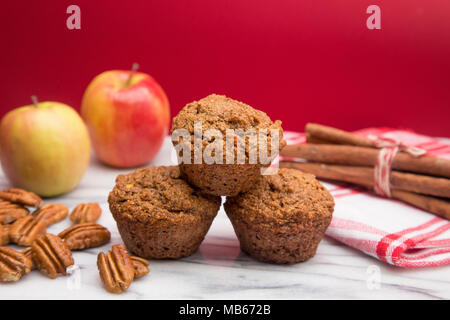 Apple Cinnamon Pecan Muffins auf einem Apple Roter Hintergrund Stockfoto