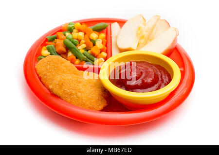 Kinder- Platte mit einer gut ausgewogenen Mahlzeit von Chicken Nuggets, Gemüse in Scheiben geschnitten und Apple Stockfoto