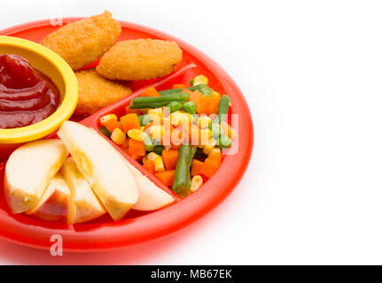 Kinder- Platte mit einer gut ausgewogenen Mahlzeit von Chicken Nuggets, Gemüse in Scheiben geschnitten und Apple Stockfoto