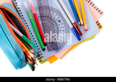 Verschiedene Schulmaterial wie Notebooks und Federmäppchen gegen einen weißen Hintergrund isoliert Stockfoto