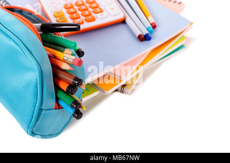 Verschiedene Schulmaterial wie Hefte, Stifte und Taschenrechner vor einem weißen Hintergrund. Flache Tiefenschärfe mit scharfen Fokus auf den Bleistift Stockfoto