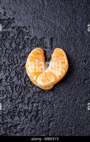 Der mandarin Schichten werden in der Form eines Herzens auf schwarzem Hintergrund gesäumt. Stockfoto