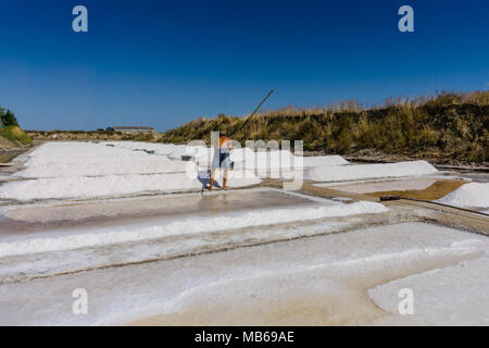 Der Mensch arbeitet die Salzgewinnung Lebensmittelindustrie. Bäder mit Salz, in Vila Real Santo Antonio, Portugal. Stockfoto