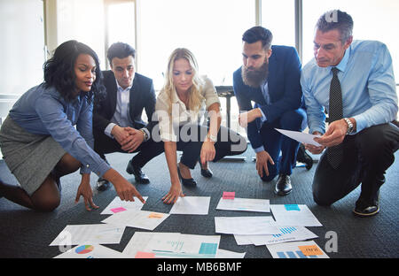 Business Team hockend im Büro diskutieren unterschiedliche Ideen Stockfoto
