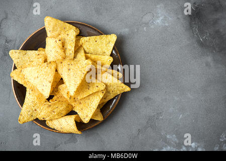 Nachos Chips. Tortilla Mais mexikanische nachos Chips in der Schüssel auf grauem Stein, kopieren. Stockfoto