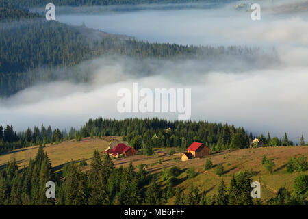 Ein friedliches Dorf in einem Tal mit Nebel bedeckt. Apuseni Gebirge, Karpaten, Rumänien. Stockfoto