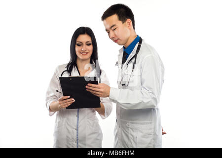 Medizinische multiethnischen Bediensteten, die die Diskussion in einem Krankenhaus Flur. Weibliche und männliche Krankenschwester trägt blaue Scrubs in einer medizinischen Klinik arbeiten. Zwei Krankenhaus Stockfoto