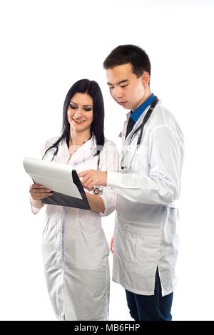 Medizinische multiethnischen Bediensteten, die die Diskussion in einem Krankenhaus Flur. Weibliche und männliche Krankenschwester trägt blaue Scrubs in einer medizinischen Klinik arbeiten. Zwei Krankenhaus Stockfoto