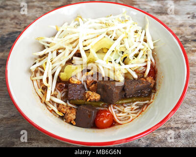 Traditionelle Reis Nudeln Suppe mit Hähnchen Blut, in Scheiben geschnittene Tomaten und getrockneten Chilis Stockfoto