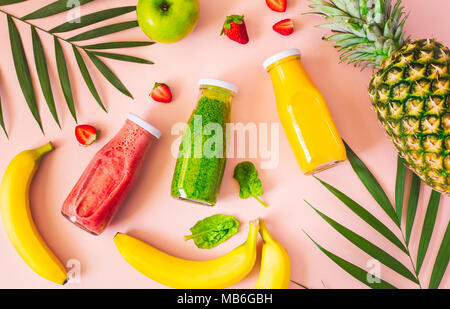 Flachbild-lay von bunten Smoothies in Flaschen mit frischem Obst und auf rosa Hintergrund, Ansicht von oben. Natürliche organische Nahrung Stil. Stockfoto