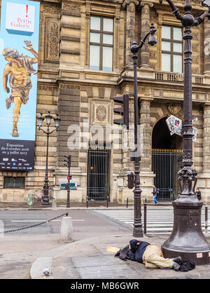 Die obdachlosen Clochard schläft direkt auf der Straße in der Nähe von Louvre. Paris, Frankreich Stockfoto