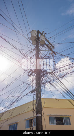 Stromleitungen in der Stadt. Transformatoren und Telefonleitungen gegen den strahlend blauen Himmel. Stockfoto